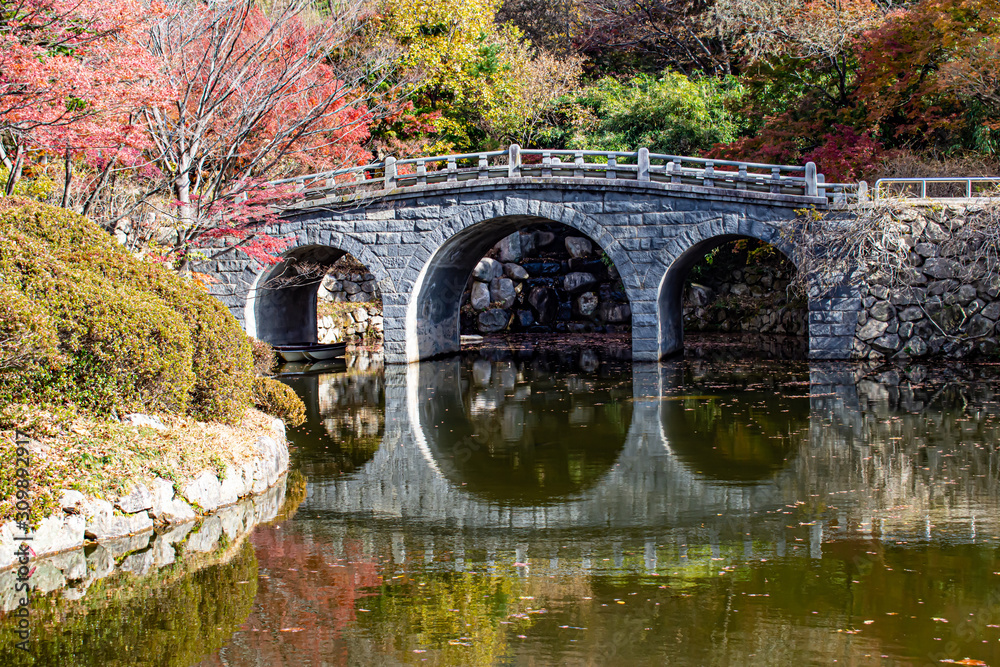 Stone bridge in reflecting in a stunning autumn setting.