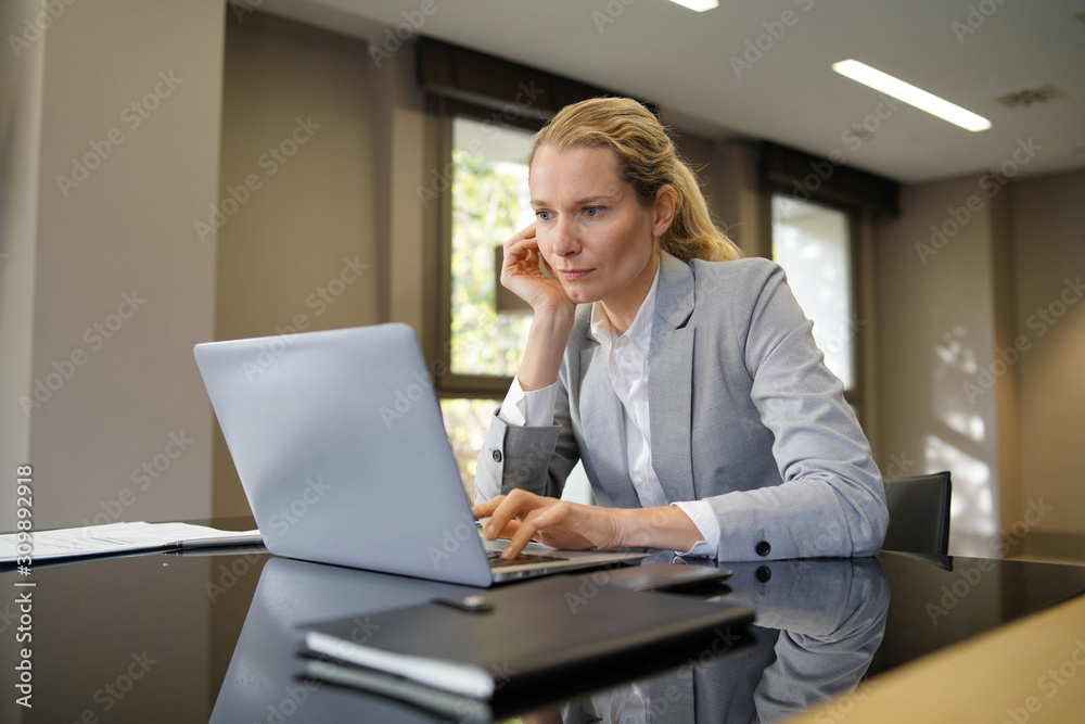 Businesswoman working on laptop in modern office