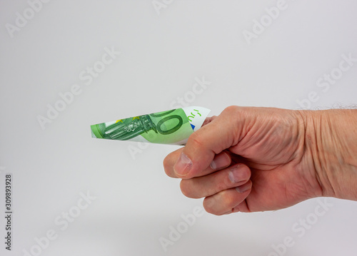 A hundred euro bill curled into cone shape on the index finger of a hand on white background