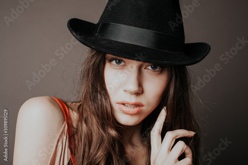 Portrait of a beautiful woman with long hair in a hat © dmitriisimakov