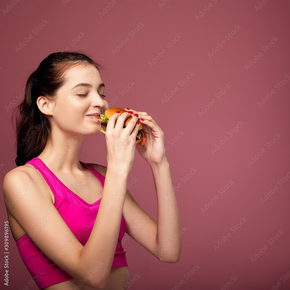 Caucasian girl eats hamburger with pleasure. Caucasian girl eats hamburger with pleasure.