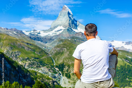 Hiker poses in front of mountain peaks range hiking backpacker old older aarp strong strength vital energetic landscape photography portrait background colorful adventure retired retirement outdoor photo