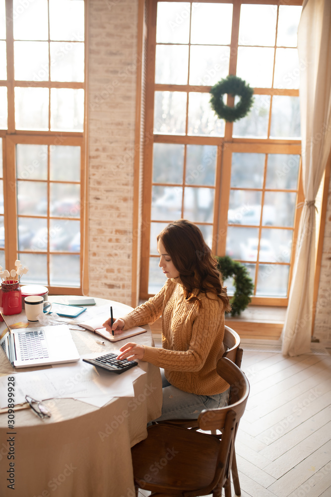 Dark-haired young woman in sweater looking busy Dark-haired young woman in sweater looking busy