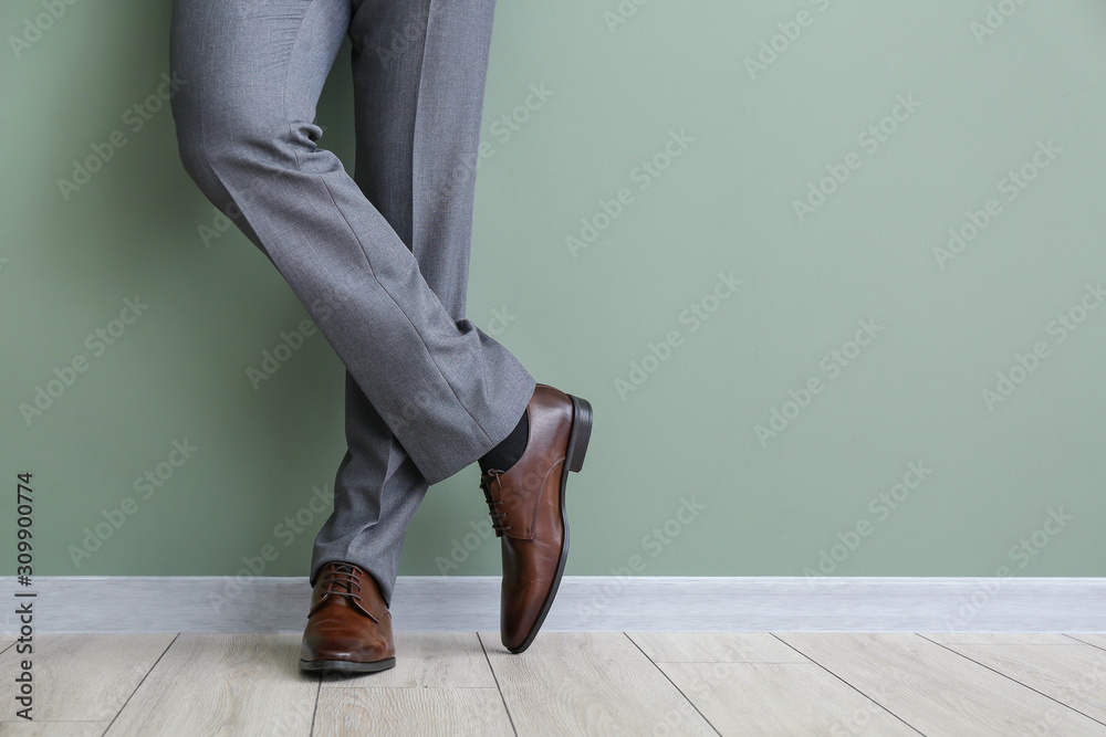 Young man in stylish shoes near color wall - obrazy, fototapety, plakaty 