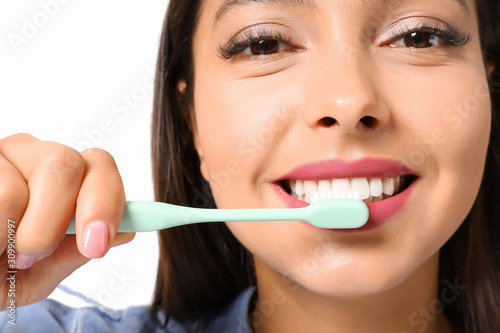 Beautiful woman brushing teeth on white background  closeup