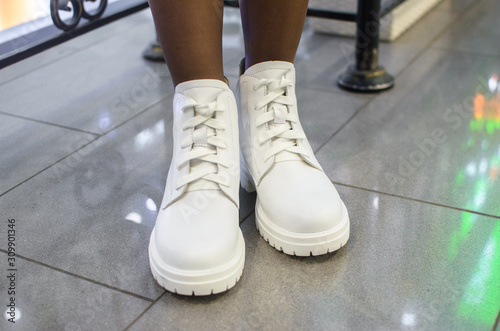 Fashionable white boots on the girl in the mall