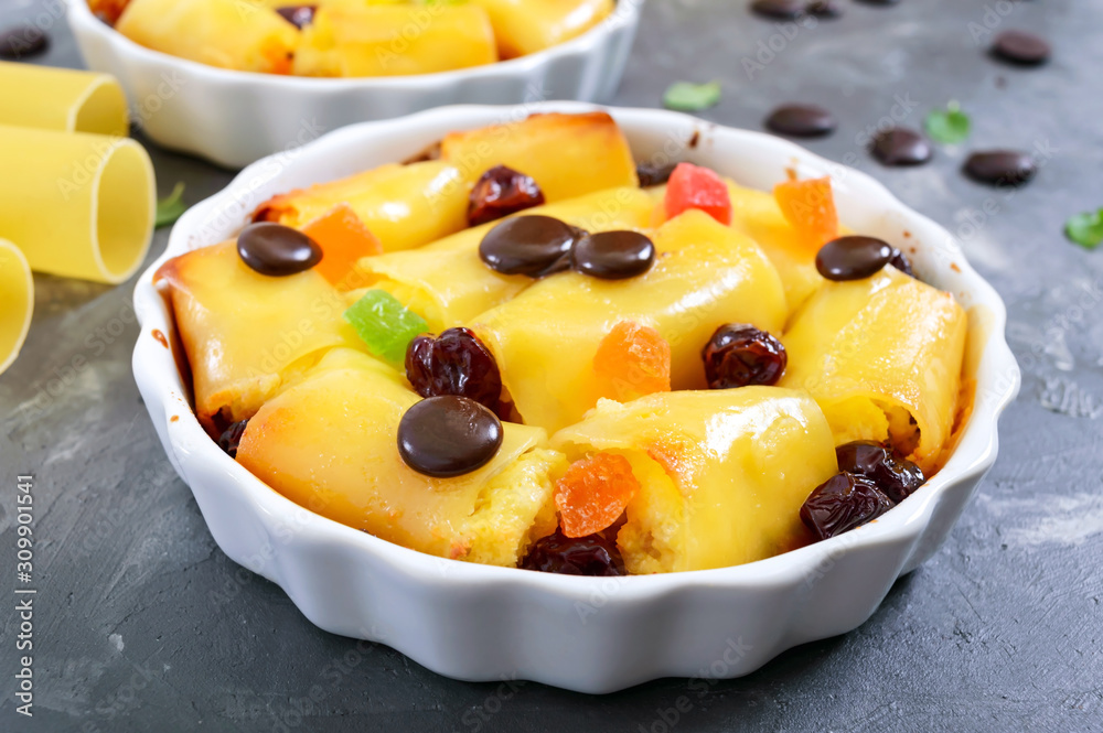 Sweet cannelloni, baked in ceramic forms. Dessert of canelloni, cottage cheese, candied fruit, dried cherries, chocolate drops. Tasty breakfast. Sweet cannelloni, baked in ceramic forms. Dessert of canelloni, cottage cheese, candied fruit, dried cherries, chocolate drops. Tasty breakfast.