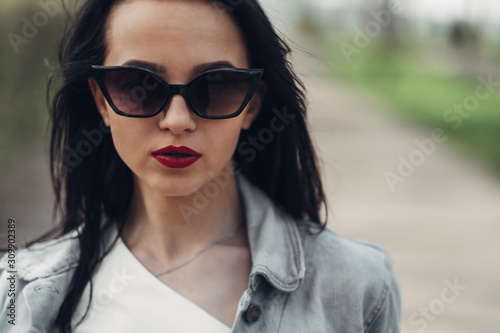Beautiful Brunette Girl in Sunglasses White Pants and Jeans Jacket, Red Lipstick