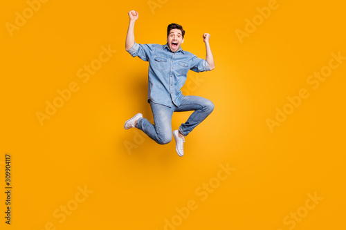 Full length body size photo of cheerful positive crazy man jumping up screaming to everyone wearing white sneakers isolated vivid color background