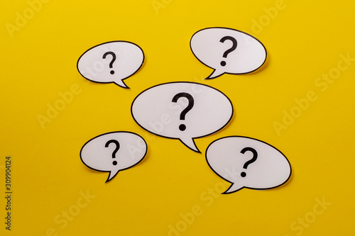 Five speech bubbles with question marks over a bright yellow background photo