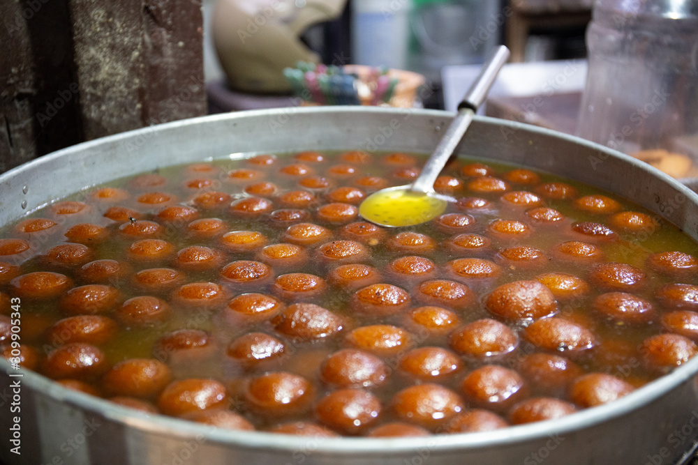 Spherical, not identified sweet deep fried balls floating in ...