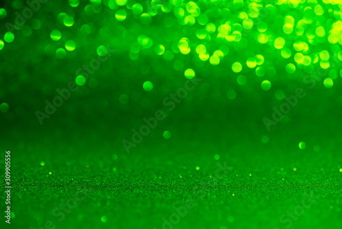 green Sparkling Lights Festive background with texture. Abstract Christmas twinkled bright bokeh defocused