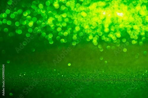 green Sparkling Lights Festive background with texture. Abstract Christmas twinkled bright bokeh defocused