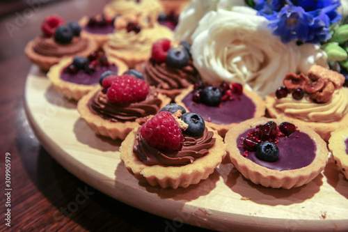 The detail of the sweet cupcakes with cream and fruits prepared for the wedding after party. 
