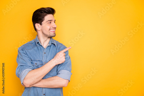 Portrait of nice attractive content cheerful cheery guy pointing forefinger aside advert copy empty black place space follow subscribe isolated over bright vivid shine vibrant yellow color background photo