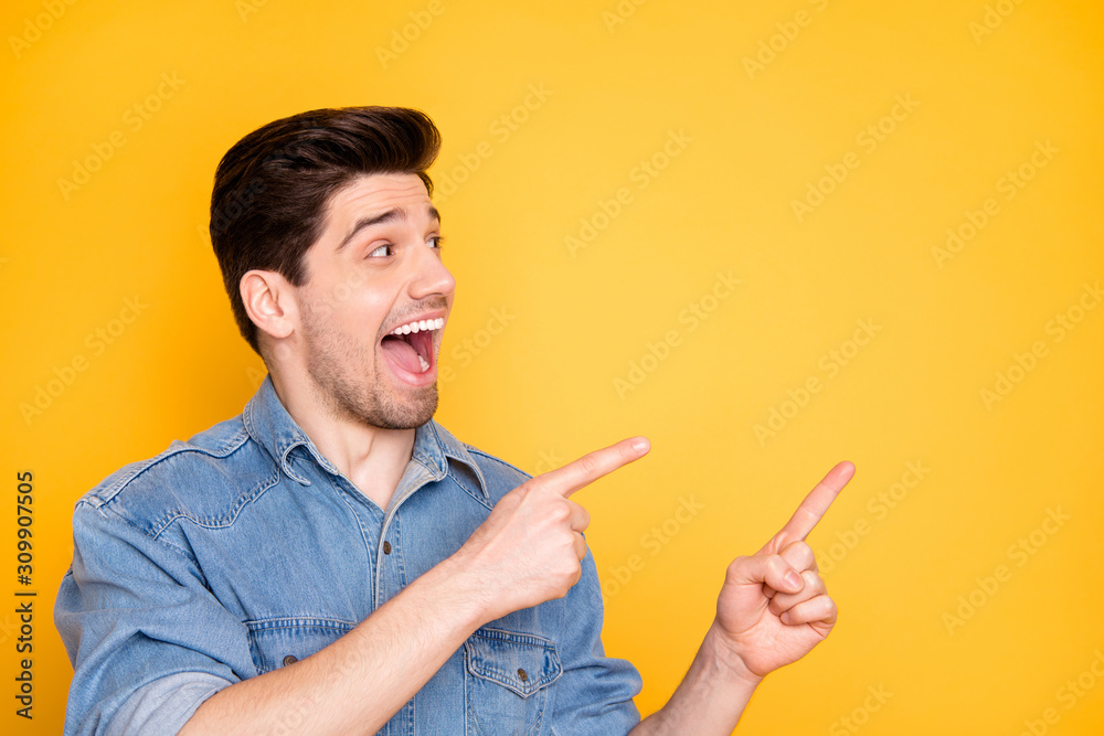 Close-up portrait of his he nice attractive funky funny glad cheerful cheery guy pointing two forefingers aside advert ad isolated over bright vivid shine vibrant yellow color background Close-up portrait of his he nice attractive funky funny glad cheerful cheery guy pointing two forefingers aside advert ad isolated over bright vivid shine vibrant yellow color background