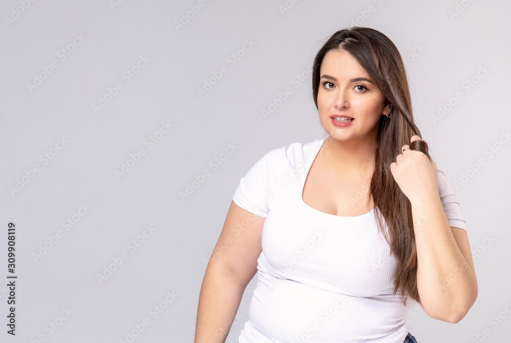 Plus Size Model with long hair twists hair on a finger Plus Size Model with long hair twists hair on a finger