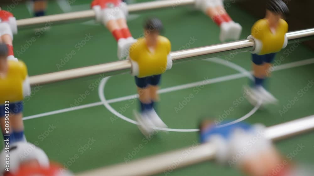 Friends Playing Table Soccer Game Closeup. People playing in table football or kicker with miniature players. Slow Motion. Shallow DOF. Playing Football Soccer on game table. Close Up. Friends Playing Table Soccer Game Closeup. People playing in table football or kicker with miniature players. Slow Motion. Shallow DOF. Playing Football Soccer on game table. Close Up.