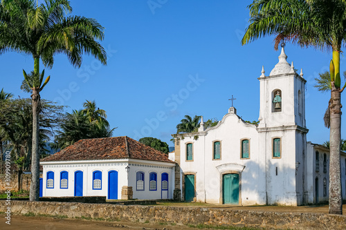 Arial view of church Nossa Senhora das Dores (Our Lady of Sorrows) with palm trees on a sunny day, historic town Paraty, Brazil