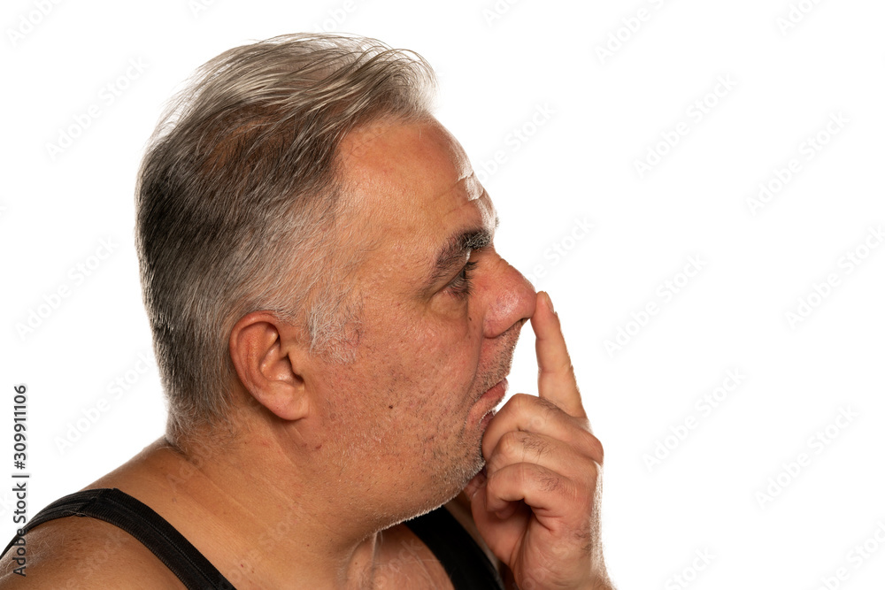 middle aged man touches his nose on white background middle aged man touches his nose on white background