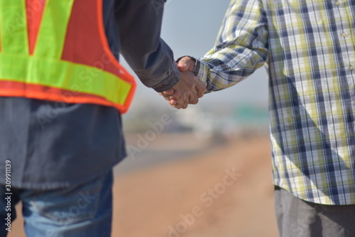 Close up people hands shake business partnership success,Shake hand concept,Engineering hands shake at work place building construction estate project success