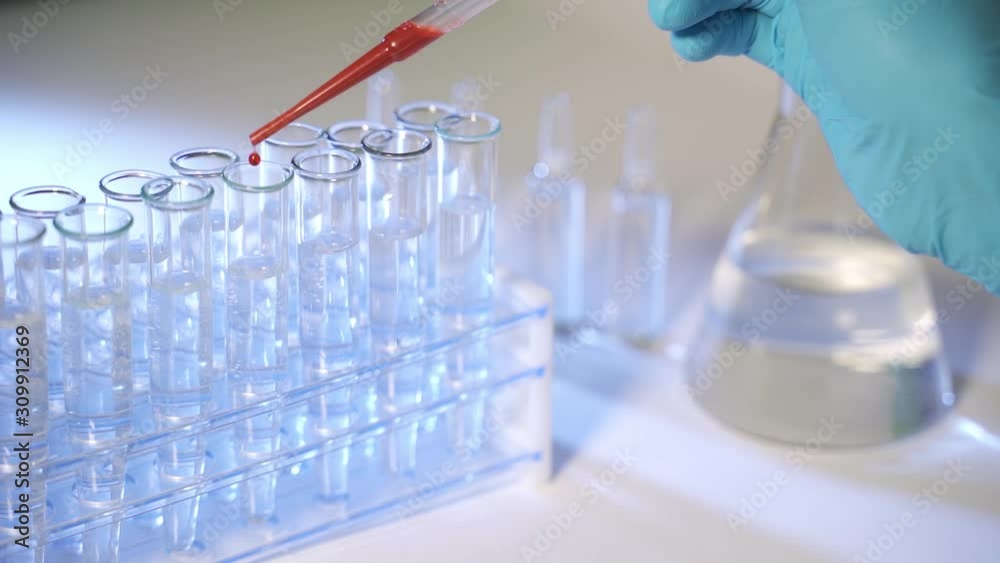 Dripping blood samples into test tubes, closeup Dripping blood samples into test tubes, closeup