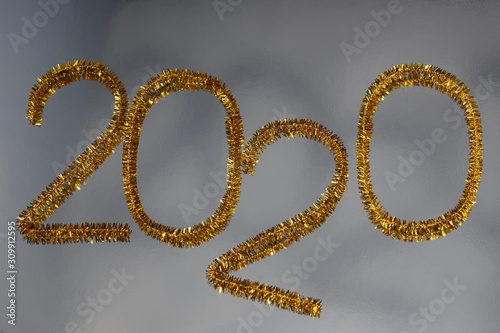 New year 2020 inscription made of glittering tinsel with a silver background.