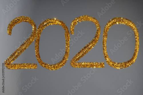New year 2020 inscription made of glittering tinsel with a silver background.