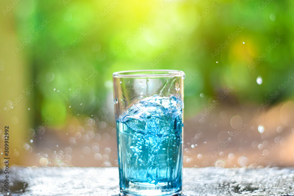 Water splashes in a glass of water on a natural background Water splashes in a glass of water on a natural background