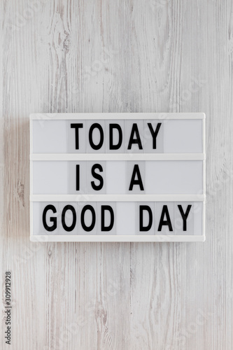 'Today is a good day' words on a lightbox on a white wooden background, top view. Overhead, from above, flat lay.