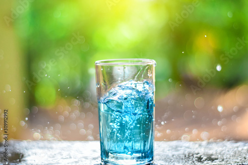 Water splashes in a glass of water on a natural background