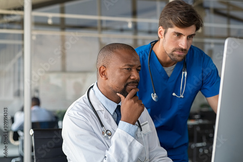 Doctor consulting patient medical record with nurse