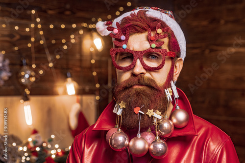 Merry Christmas and happy New Year. Bearded man having fun near Christmas tree indoors. Santa winter portrait. Christmas preparation - Santa celebrating New Year.