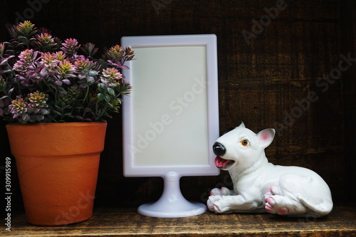 Blank Display frame stand with Dog Stucco doll decoration on wooden background