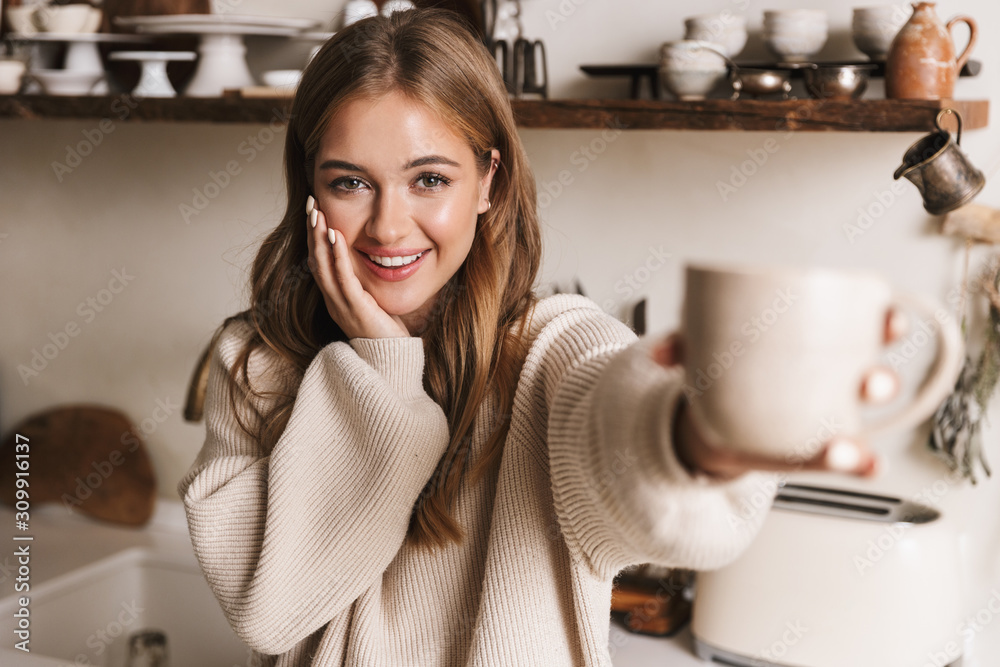 Image of beautiful funny woman drinking coffee and looking at camera Image of beautiful funny woman drinking coffee and looking at camera