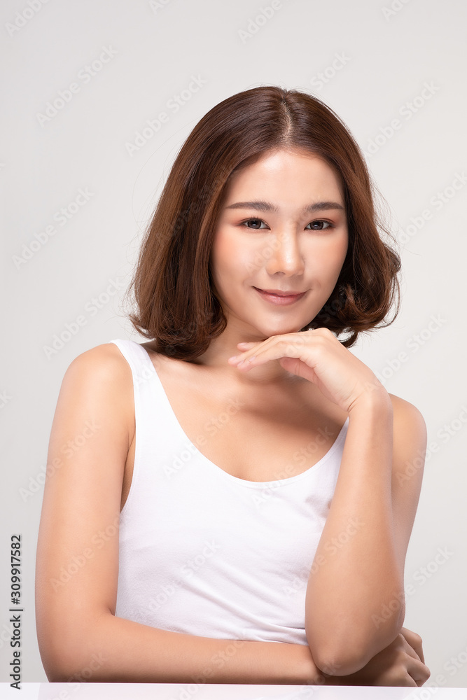 Beautiful Young Asian Woman with short hair Looking While Touching Chin feeling so happy and cheerful with healthy Clean and Fresh skin,isolated on gray background,Beauty Cosmetics Concept Beautiful Young Asian Woman with short hair Looking While Touching Chin feeling so happy and cheerful with healthy Clean and Fresh skin,isolated on gray background,Beauty Cosmetics Concept