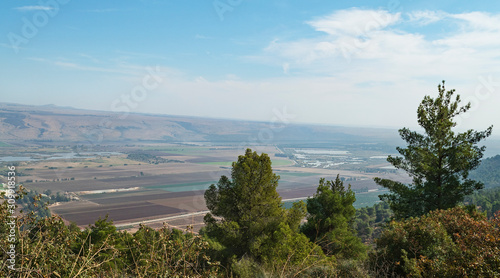 Hula Lake Park on the left and the hula nature reserve on the right from near the reut museum with trees in the foreground and the golan heights in the background photo