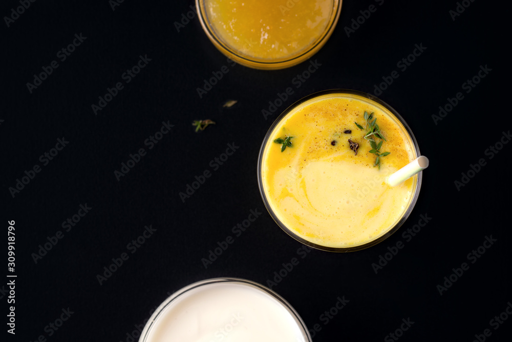 Lassi mango drink next to jam and yogurt on a black background Lassi mango drink next to jam and yogurt on a black background