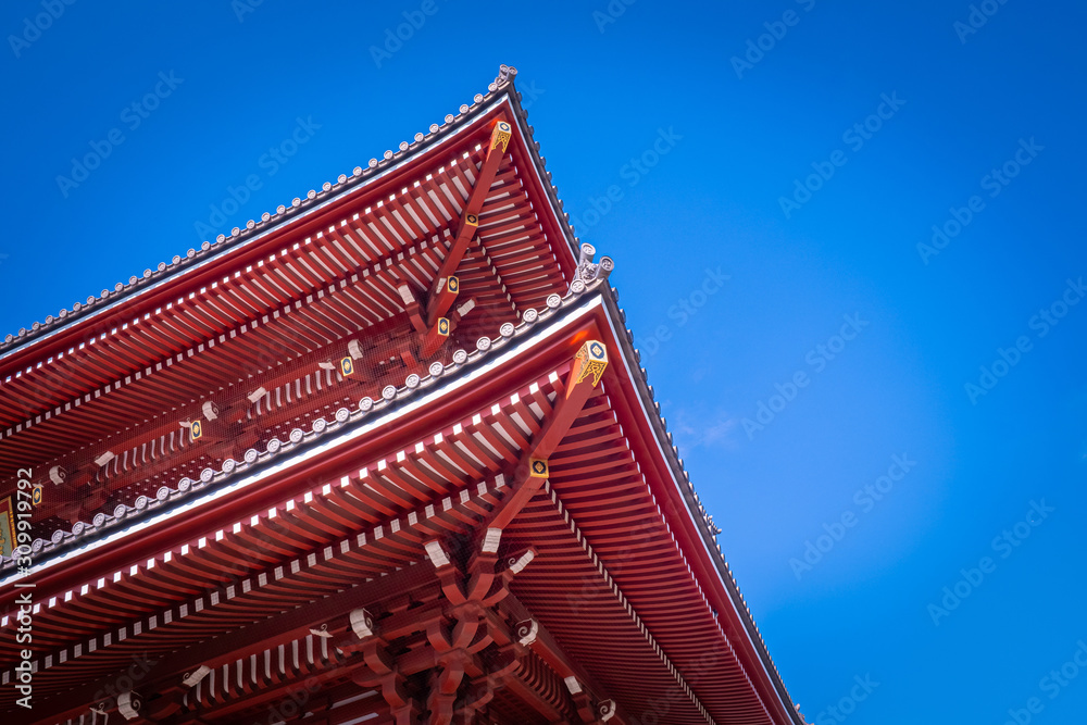 Japan. Tokyo. Roof of the temple of Asakus on the background of blue sky. Exterior of a japanese building. Temple of the Three Deities. Sensoji Church. Exterior of the temple roof with a swastika