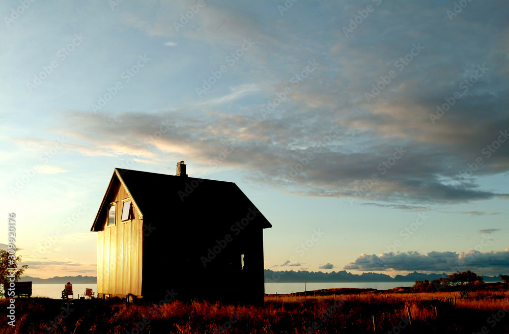 Norwegen, Haus in der Abendsonne am Strand mit Blick auf die Lofoten Norwegen, Haus in der Abendsonne am Strand mit Blick auf die Lofoten