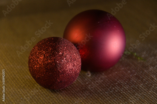 Two brighly red Christmas balls with glitter