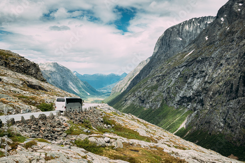 Trollstigen, Andalsnes, Norway. Bus Goes On Famous Mountain Road Trollstigen. Norwegian Landmark And Popular Destination. Norwegian County Road 63 In Sunny Summer Day