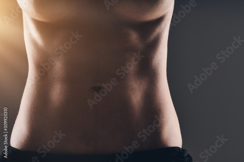 Woman sexy abdomen over dark background