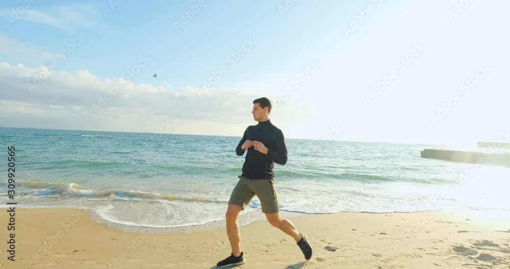Young fit male runner training outdoors on the morning sunny beach Young fit male runner training outdoors on the morning sunny beach