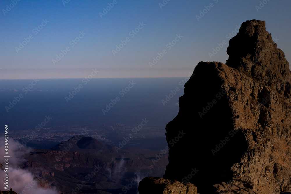 Big Volcanic black rock over cliff