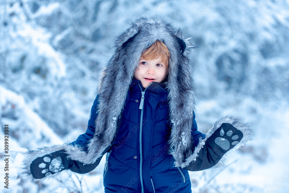 Kids in winter clothes. Cute little kid enjoying in the winter park in snow. Funny kid coming to the winter forest on snow landscape. Kids in winter clothes. Cute little kid enjoying in the winter park in snow. Funny kid coming to the winter forest on snow landscape.