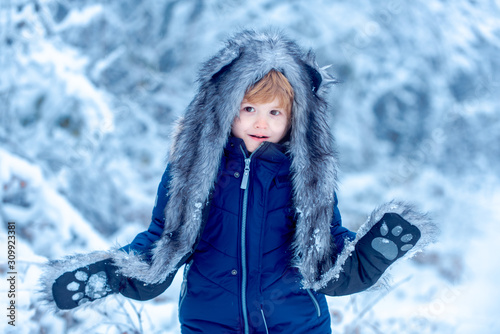 Kids in winter clothes. Cute little kid enjoying in the winter park in snow. Funny kid coming to the winter forest on snow landscape. © Volodymyr