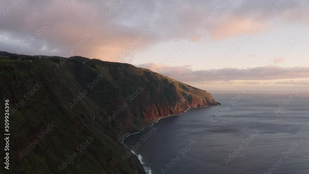 Aerial view of dramatic coastline during sunset. Beautiful cinematic scene. Flying high above the ocean.