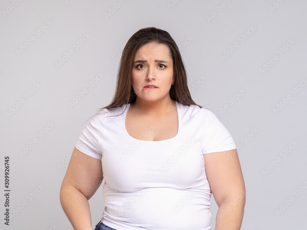 Plus Size Model with long hair Grimacing, biting her lip Plus Size Model with long hair Grimacing, biting her lip