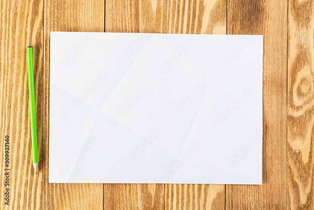 Sheet of paper lying on wooden table Sheet of paper lying on wooden table